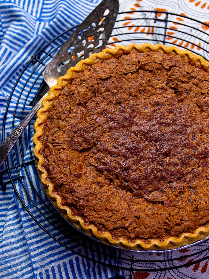 Chocolate Chess Pie on a cooling rack with a serving piece.