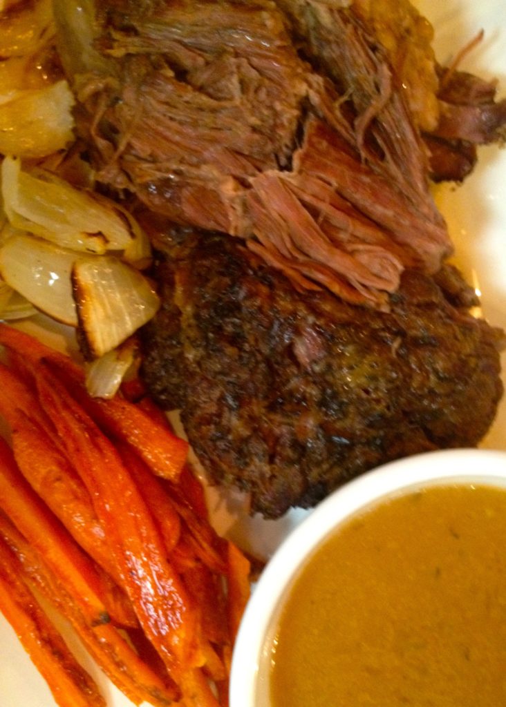 beef pot roast cooked in crock pot or slow cooker with carrots and onions and gravy