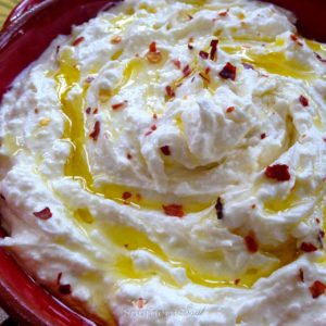 Whipped Feta, blended until smooth then topped with olive oil and red pepper flakes. Serve with pita chips for a delicious appetizer!