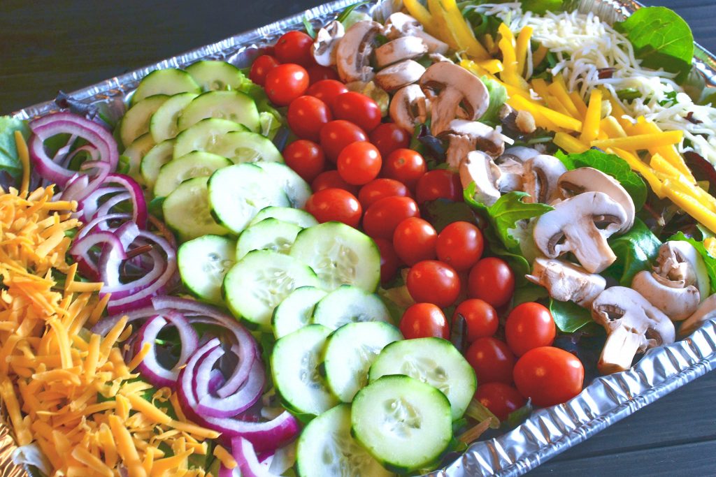 Salad for a crowd with tomatoes, cucumbers, onions, mushrooms and cheese with a homemade vinaigrette is a hit at any gathering or party.