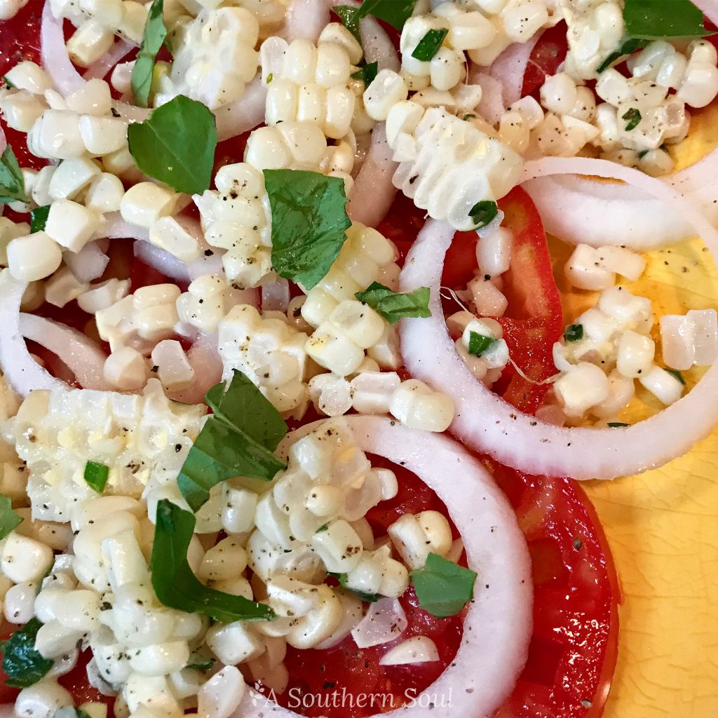 summer salad with tomatoes, onions, corn and herbs