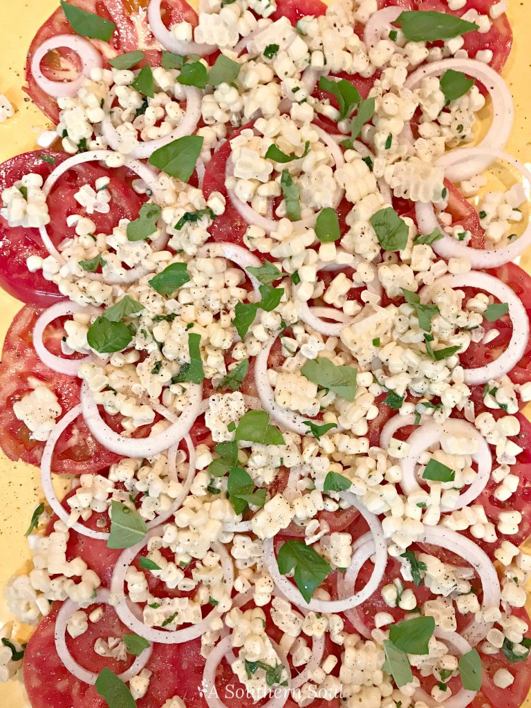 tomatoes, vidalia onion, corn, basil salad for summer on platter