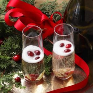 Make your holiday season extra bright with this signature cocktail! Mistletoe Mimosas, made with sparkling apple cider and Proscecco with chilled fruit is a great way to share a little holiday happiness.