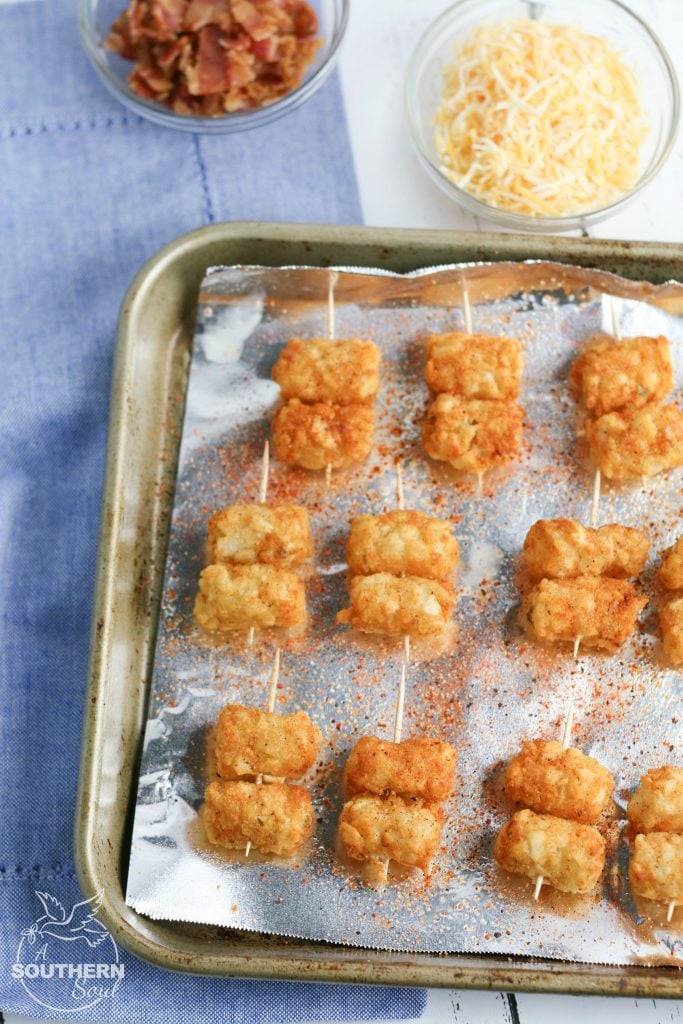 Tater Tots made into loaded little appetizer bites are a great appetizer or snack. Topped with cheese & bacon then dipped into creamy sour cream, they become a savory treat everyone will love.