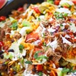 Pulled Pork cooked in the Instant Pot is tender and juice. It's then turned into nachos loaded with cheese, beans, corn, peppers, avocado, BBQ sauce and sour cream for a dish that is out of this world!