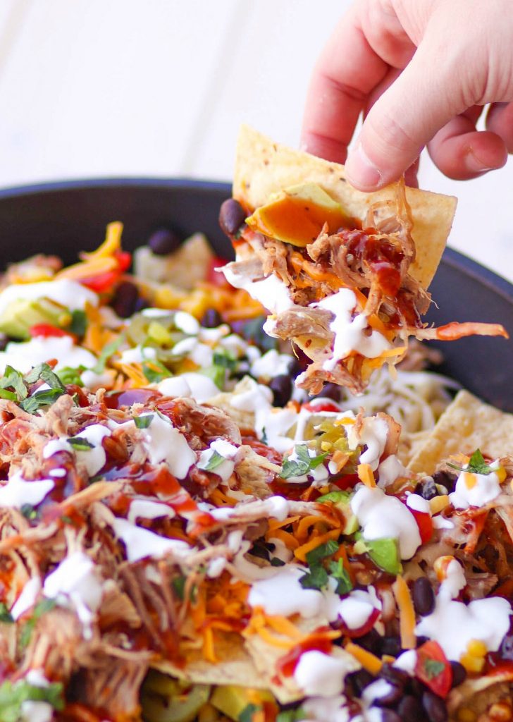 Pulled Pork cooked in the Instant Pot is tender and juice. It's then turned into nachos loaded with cheese, beans, corn, peppers, avocado, BBQ sauce and sour cream for a dish that is out of this world!