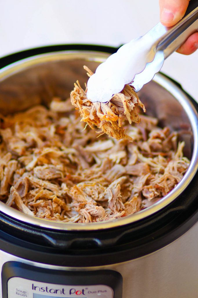 Pulled Pork cooked in the Instant Pot is tender and juice. It's then turned into nachos loaded with cheese, beans, corn, peppers, avocado, BBQ sauce and sour cream for a dish that is out of this world!