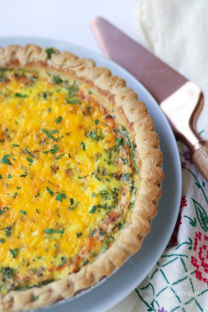 बनाने में आसान चेडर, मोज़ेरेला और परमेसन से बना थ्री चीज़ क्विच नाश्ते, ब्रंच या सप्ताह के रात्रि भोजन के लिए एक बेहतरीन मुख्य व्यंजन है।