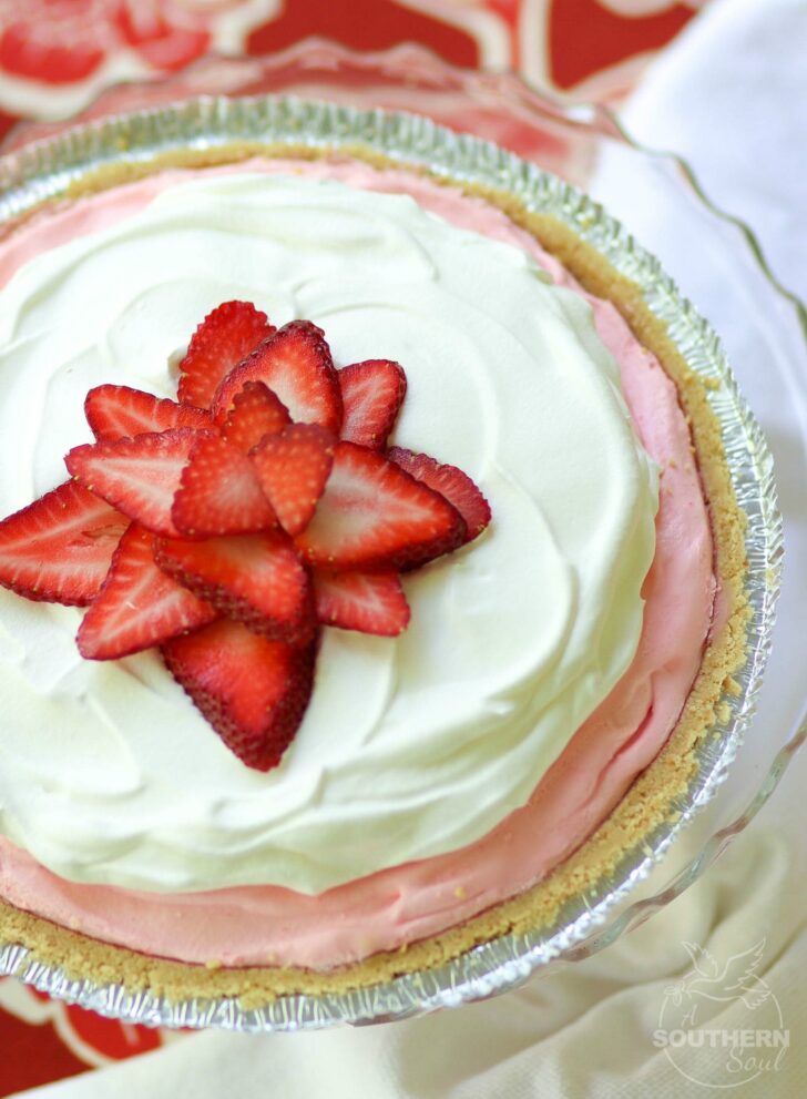 Strawberry Jello Pie made with fresh whipped cream and strawberry jello is an easy to make dessert that is cool and delicious. It's perfect for the holidays, potluck or covered dish suppers or a weeknight meal.