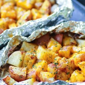 Red potatoes flavored with ranch seasoning then cooked on the grill in foil packets are loaded with cheese for a side dish that is perfect for any cookout or BBQ!