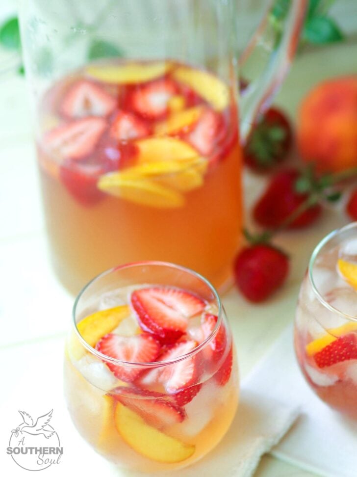 Rose sangria flavored with peach schnapps, peach juice with fresh fruit is a cool drink that's excellent for summertime!,