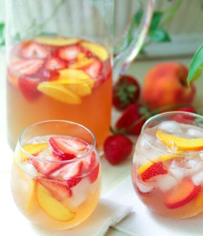 Rose sangria flavored with peach schnapps, peach juice with fresh fruit is a cool drink that's excellent for summertime!,