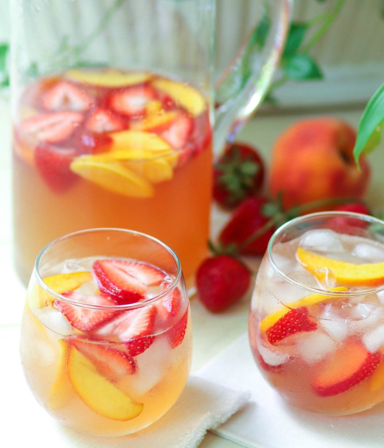 Rose sangria flavored with peach schnapps, peach juice with fresh fruit is a cool drink that's excellent for summertime!,