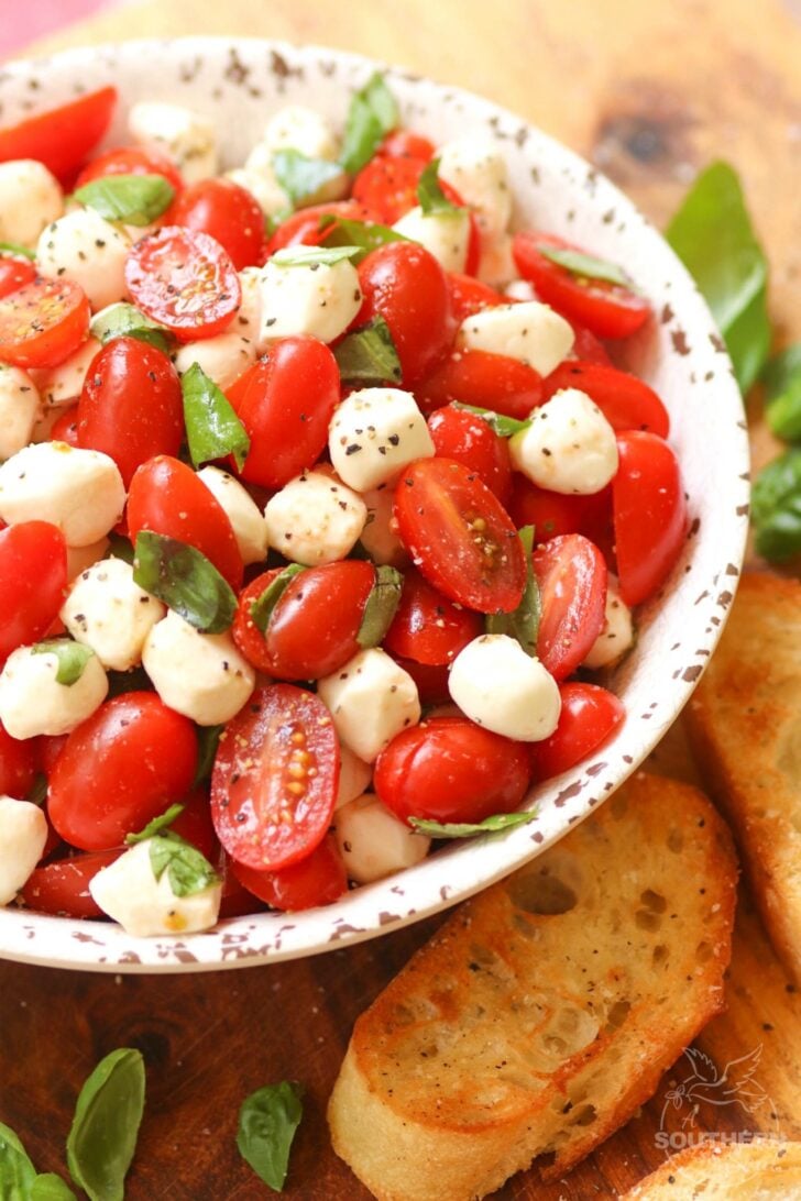 Garden fresh tomatoes and herbs tossed with mozzarella, along with basil in a two ingredient dressing of olive oil and balsamic vinegar might just be the most simple, most delicious salad ever!