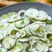 Creamy Cucumber Salad is a simple side dish that's full of fresh flavor. Make with cucumbers and onions in a dressing of sour cream, vinegar, sugar, dill, salt, pepper and garlic it's a cool creamy salad to enjoy any time of the year!