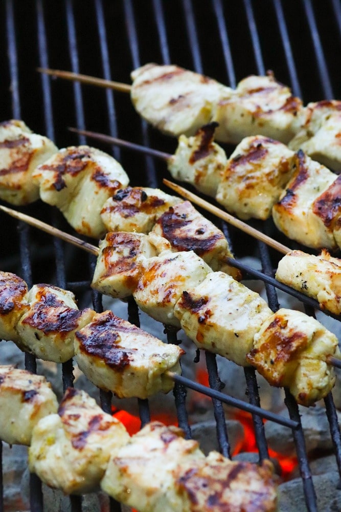 Grilled Chicken Souvlaki Skewers are juicy and tender. Make with lemon juice, oregano, garlic, salt and pepper. Add in a chopped salad with tomatoes, onions and cucumbers and you've got a meal your friends and family will love!
