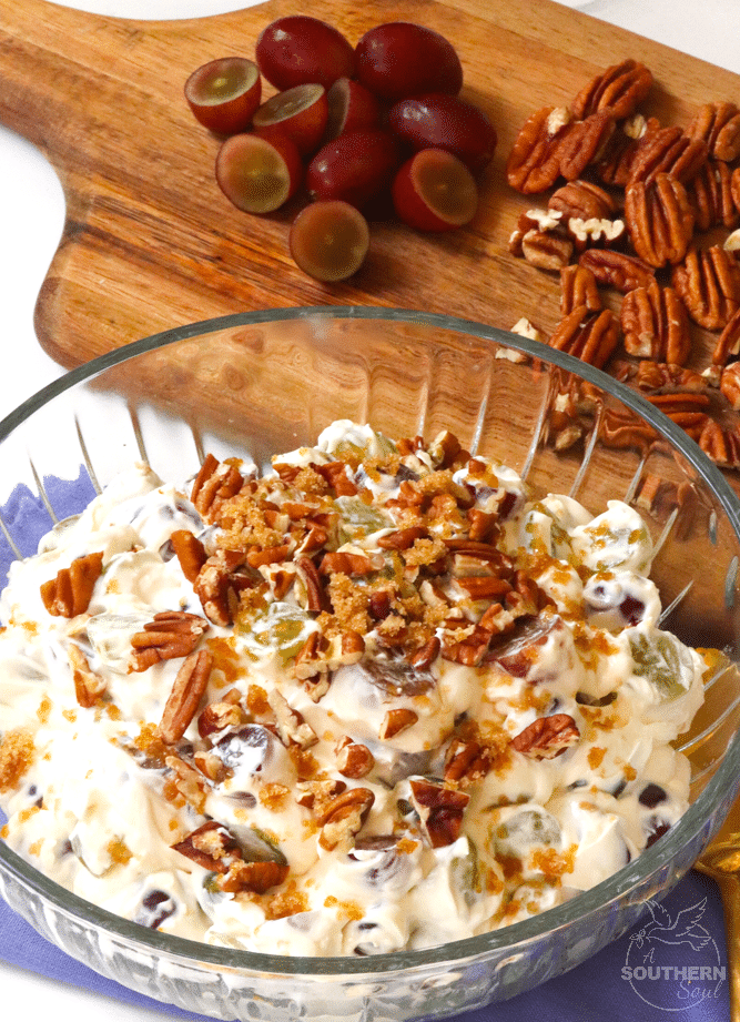 Simple grape salad made with red and green grapes, cream cheese, sour cream and sugar then topped with pecans and brown sugar is an irresistible side dish or dessert!