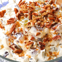 Simple grape salad made with red and green grapes, cream cheese, sour cream and sugar then topped with pecans and brown sugar is an irresistible side dish or dessert!