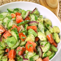 Cucumber Tomato Avocado Salad is full of fresh, bright flavor. Made with sliced cucumbers, tomatoes and avocados drizzled with a simple dressing of olive oil, vinegar mixed with garlic is great to serve any time of the year.