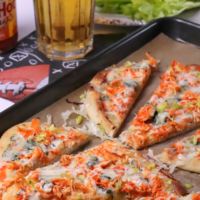 Buffalo Chicken Flatbread Pizza is great for gameday, parties or a quick and easy weeknight meal. Made with crockpot buffalo chicken, ranch dressing, blue cheese and topped with buffalo sauce.