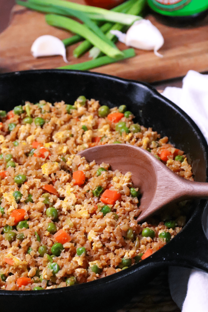 Cauliflower Fried Rice is a low carb version of your favorite Chinese take out dish. Made with cauliflower, eggs, carrots, and peas, it's seasoned with soy sauce and garlic all ready in less than 20 minutes!