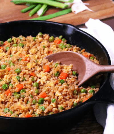 Cauliflower Fried Rice is a low carb version of your favorite Chinese take out dish. Made with cauliflower, eggs, carrots, and peas, it's seasoned with soy sauce and garlic all ready in less than 20 minutes!