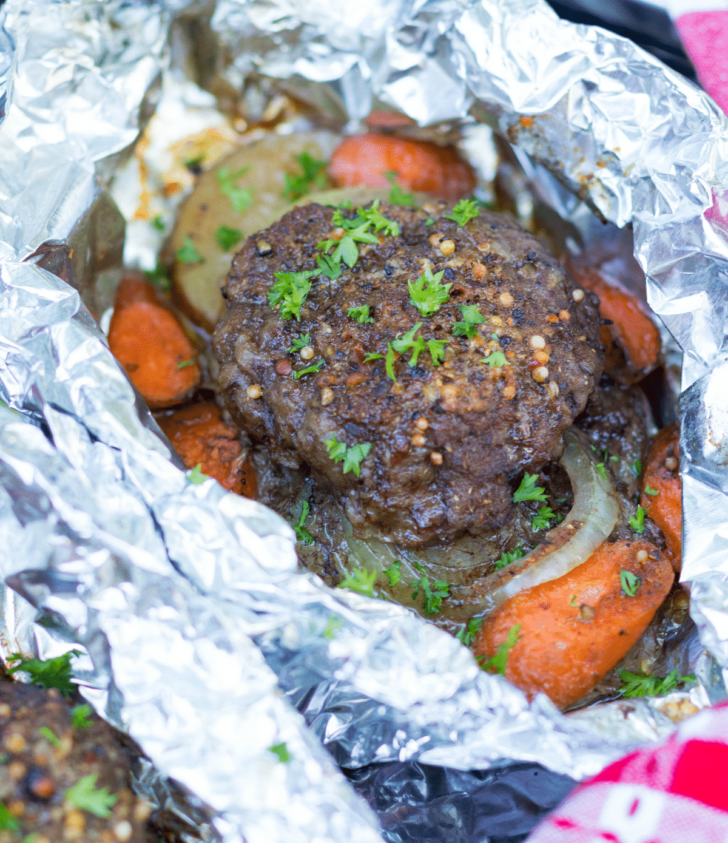 Hobo Dinner Foil Packs are made with ground beef, sliced potatoes, carrots and onions seasoned with butter and Montreal Steak Seasoning. They can be cooked on the grill, over a camp fire or in the oven.