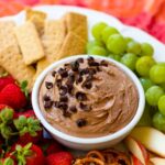 Chocolate Dip in bowl on fruit platter with cookies and pretzels.