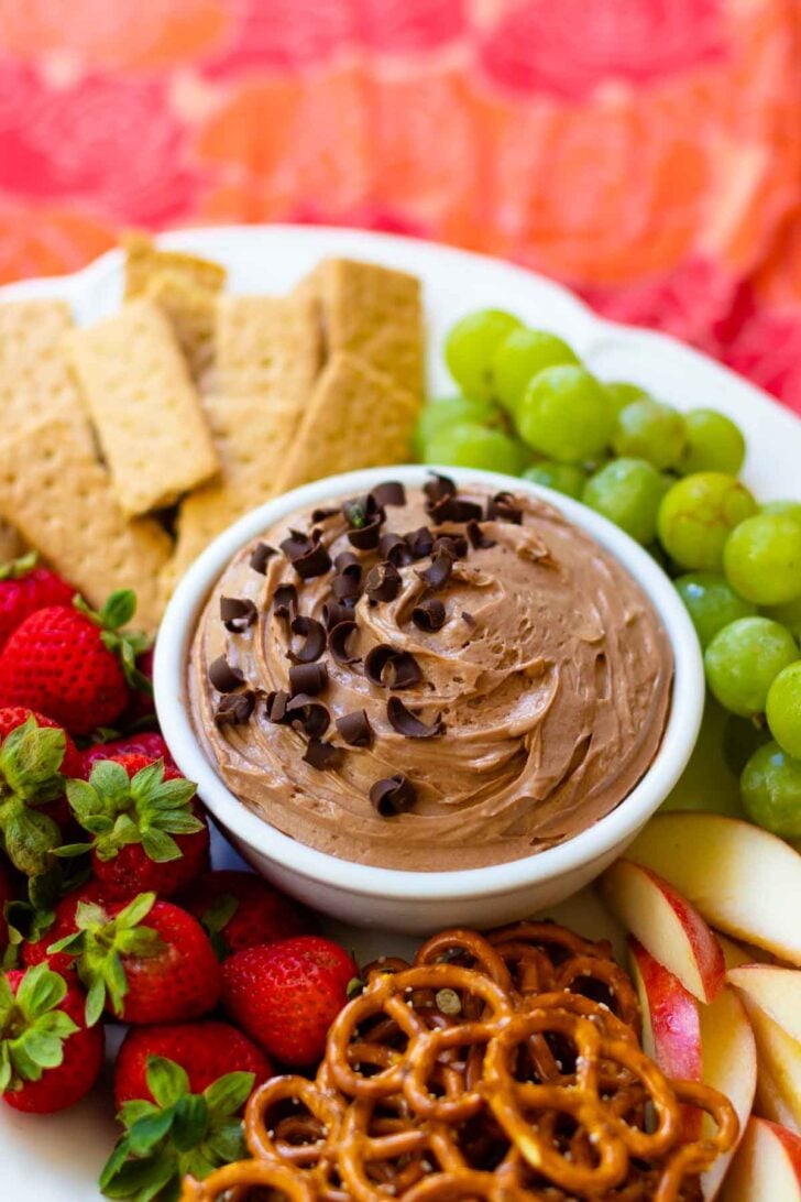 Chocolate Dip in bowl on fruit platter with cookies and pretzels.