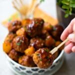 Crock Pot Hawaiian Meatballs with sauce on a small skewer.