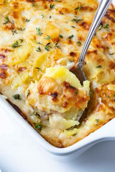 Beautifully golden and perfectly cooked Scalloped Potatoes in a casserole dish.