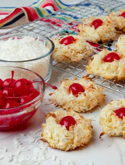 Ambrosia Cookies with red cherries and white coconut on a rack cooking.