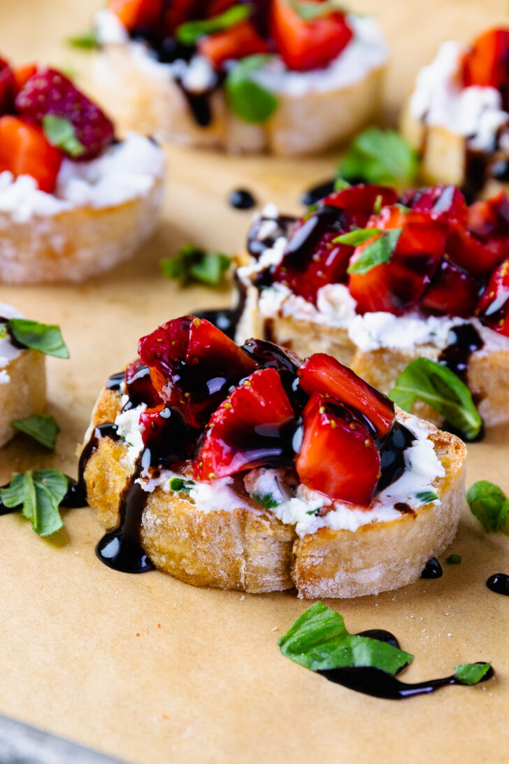 Strawberries and goat cheese with herbs on toast with balsamic drizzle.