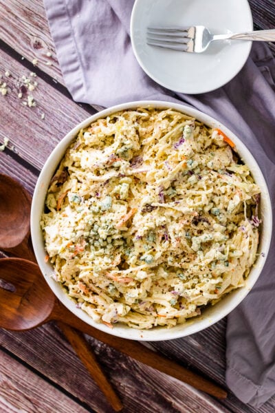 Blue Cheese Coleslaw in a bowl with small white bowl and fork for serving.