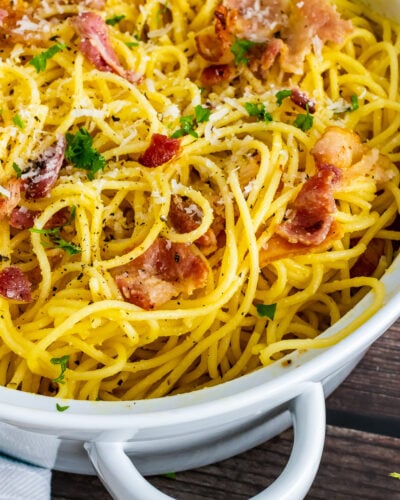 Pasta Carbonara in a white pot with bacon and cheese.