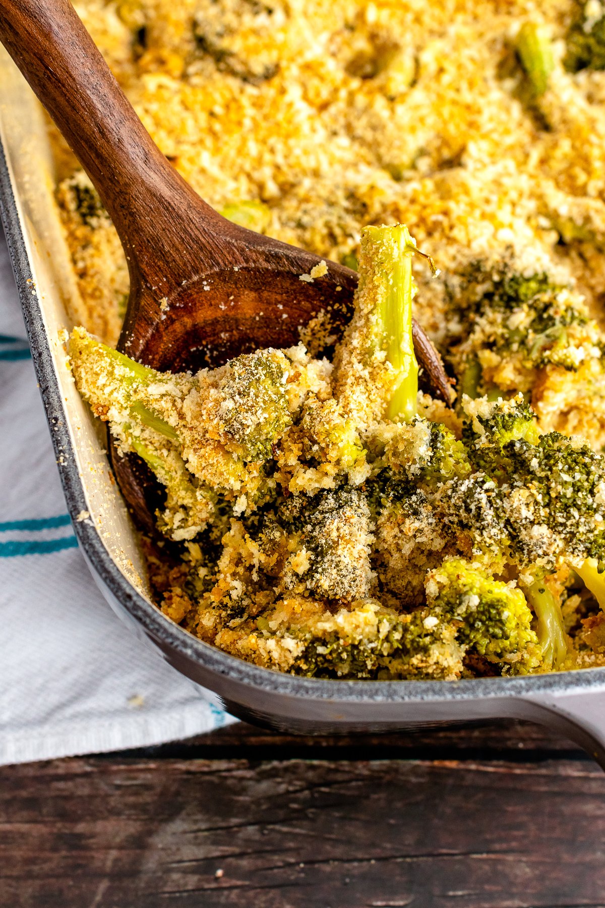 Easy to make Broccoli Casserole served with a wooden spoon for dinner.