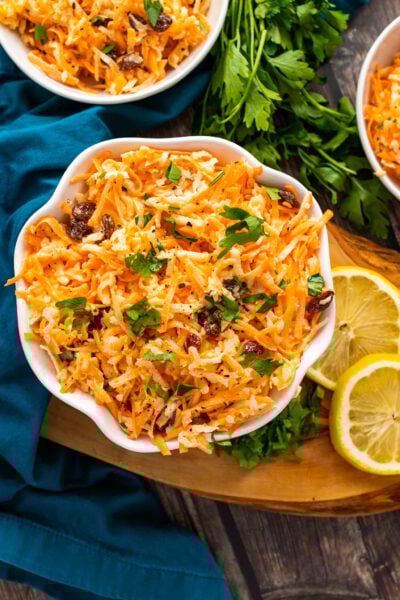 Carrot Apple Salad with fresh parsley in a white bowl.