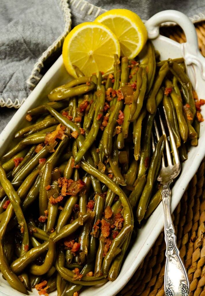 Crock Pot Green Beans served with bacon and lemon slices.