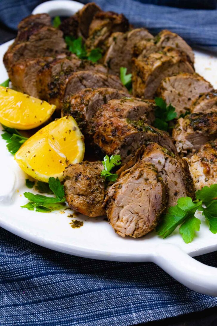 Roasted pork tenderloin with lemons and parsley.