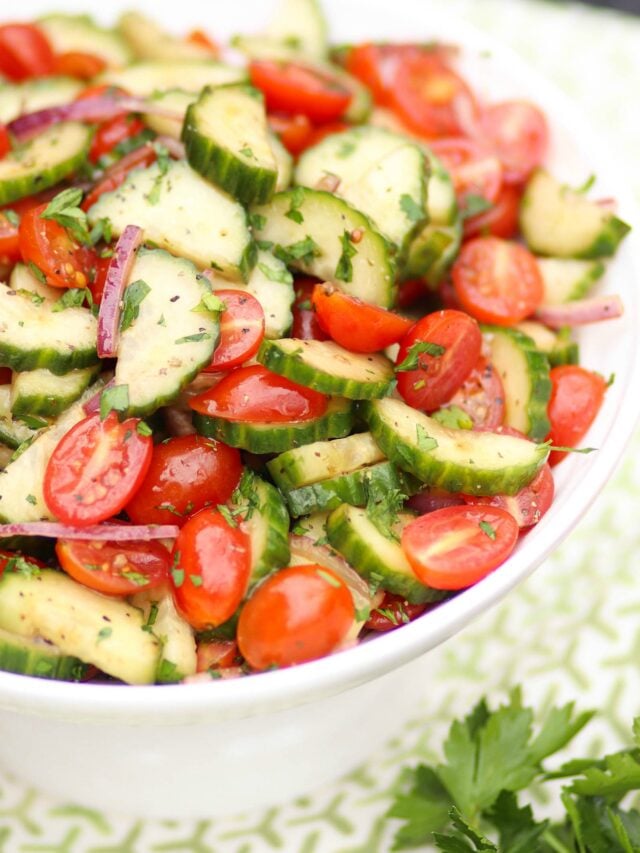 Tomato Cucumber Salad with homemade dressing in a white bowl.