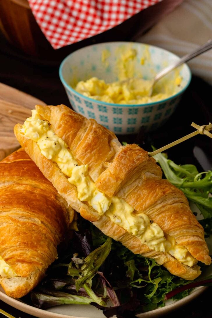 Egg salad sandwich served with salad.