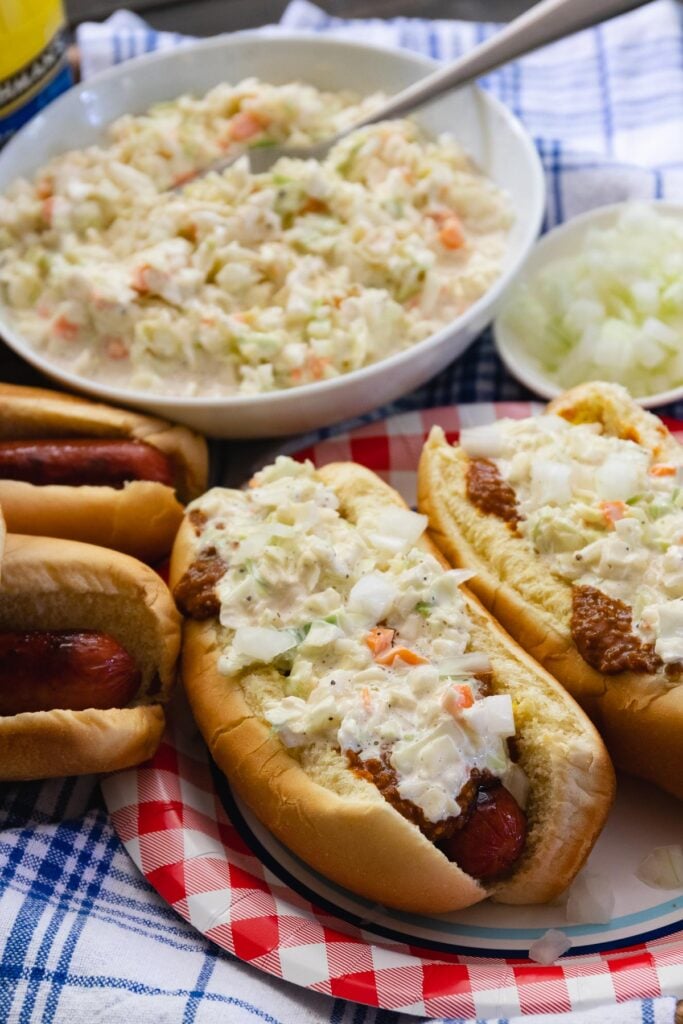 Carolina Slaw Dogs are loaded with flavor! Made with hot dogs in buns, mustard, chili, onions and creamy coleslaw.