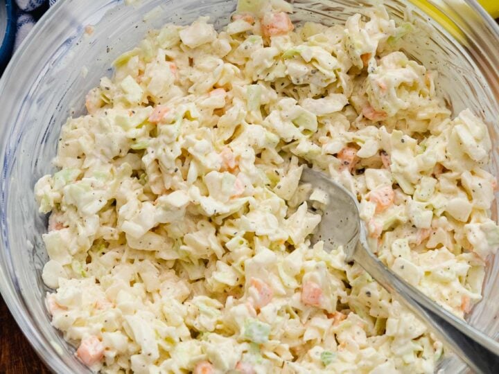 Creamy Southern coleslaw with shredded cabbage and carrots in a white bowl, a classic BBQ side dish.