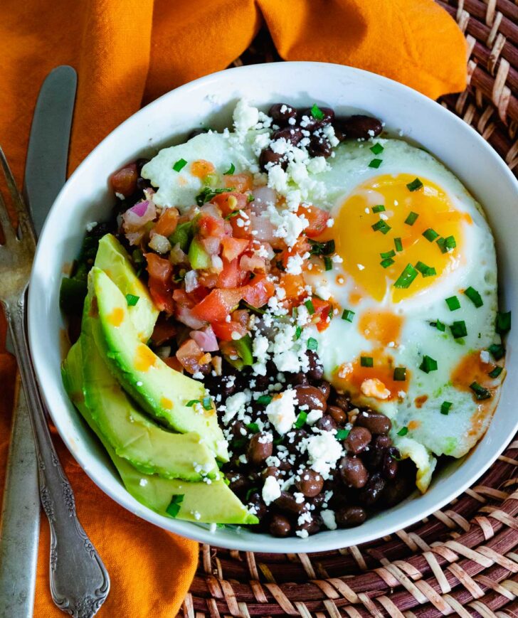 Healthy and delcious black bean breakfast burrito bowls with fried eggs, salsa and avocados.
