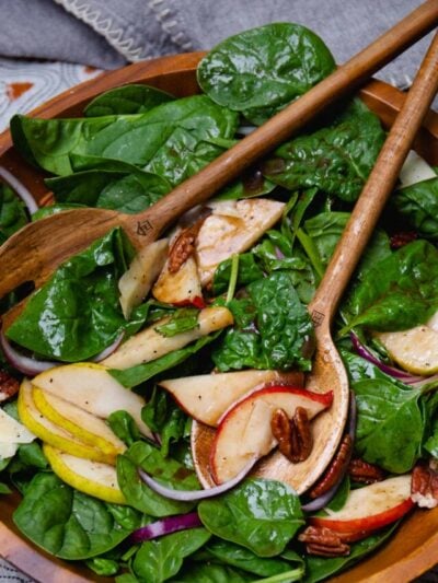 Spinach Pear Salad with balsamic dressing served with wooden tongs for the prefect fall salad.