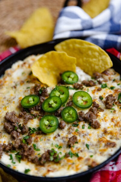 Tortilla chip dipped into Sausage Jalapeno Popper Dip baked in a cast iron skillet is creamy, meaty and spicy. It's a great hot appetizer to serve at family gatherings, parties, game day or anytime you are feeding a crowd.
