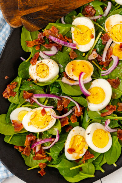 Fresh spinach, sliced red onion, crispy cooked bacon and boiled egg tossed in a warm bacon dressing tossed with wooden thongs.
