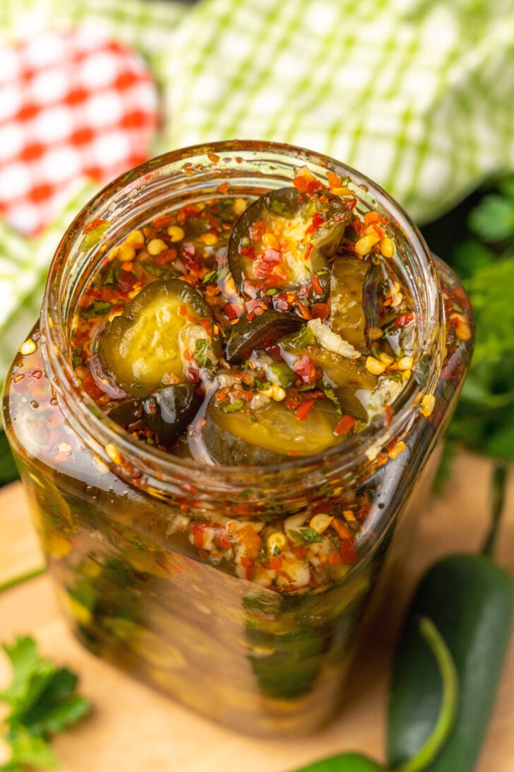 Jar or Sweet Heat Pickles marinated in red pepper, sugar, garlic, parsley and jalapeños are crazy delicious and so easy to make. They are great as a snack, with burgers, chicken, and perfect for a charcuterie board!