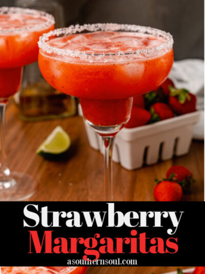 Sugar, salt rimmed glass rimmed glass with a fresh strawberry margarita with ice made with fresh fruit and limes.