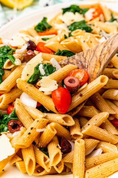 Whole wheat penne pasta tossed with fresh tomatoes, spinach, black olives in lemon juice and olive oil the topped with shaved Parmesan Cheese.
